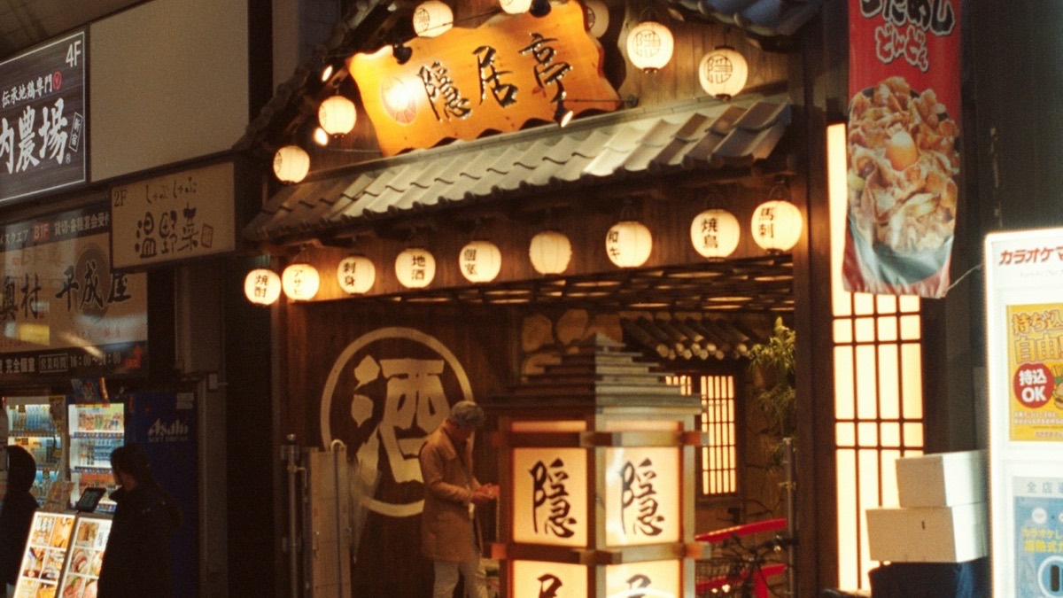 A Japanese restaurant entrance lit by lanterns at night