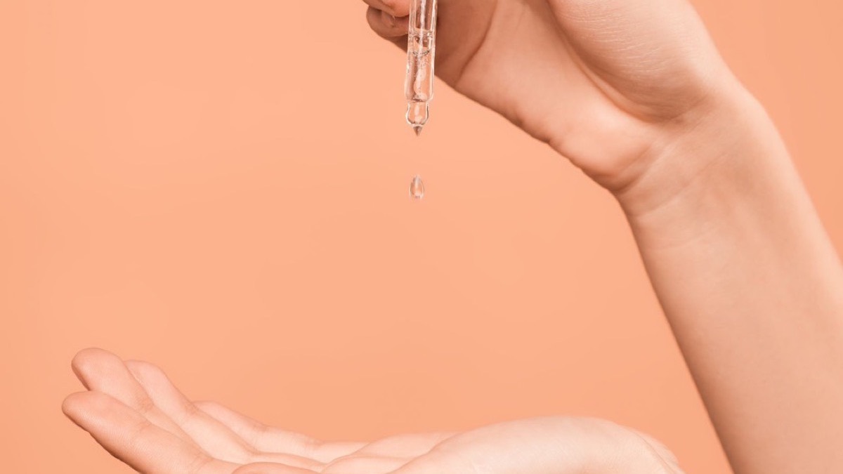 A serum dropper held over an open palm
